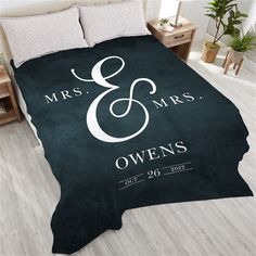 a bed covered in a black and white blanket with the words mr and mrs on it