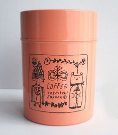 a pink coffee canister sitting on top of a white table