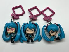 three keychains with cartoon characters on them sitting next to each other in front of a white background