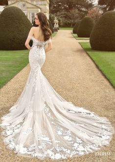 a woman in a wedding dress is standing on the side walk with her back to the camera