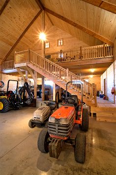 a large garage with several vehicles parked in it and stairs leading up to the second floor