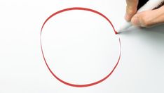 someone is drawing a circle with red marker