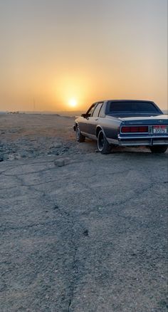 a car parked in the desert at sunset