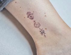 a small tattoo on the ankle of a woman's foot with an owl and flower design