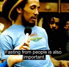 a man holding a microphone in front of other people with words on it that say fasting from people is also important