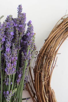 lavender flowers are arranged next to a wicker wreath