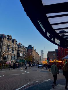 people are walking down the street in front of some buildings