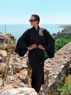 This gothic long kimono robe is a striking piece that blends dark elegance with luxurious comfort. Made from black satin, this kimono robe for women exudes a sense of sophistication and mystique, perfect for those who appreciate a gothic aesthetic. The bell-sleeve dress design adds a touch of drama and flair, enhancing the overall allure of the robe. Ideal as a gift for your wife, this elegant dressing gown is both practical and stylish, making it a cherished addition to her wardrobe.  ◌ SIZE: - Satin Kimono Dress, Satin Bathrobe, Dress Bell Sleeve, Elegant Dressing, Robe For Women, Dark Elegance, Satin Noir, Dress Luxury, Black Kimono