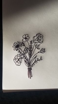 a drawing of some flowers on a piece of paper with black ink in the middle