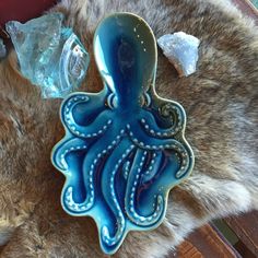 an octopus shaped cookie sitting on top of a table next to some ice cubes