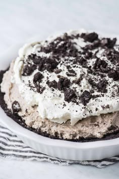 there is a pie with oreo cookies on it in the dish and white plate