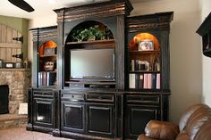 a living room with a fireplace and entertainment center