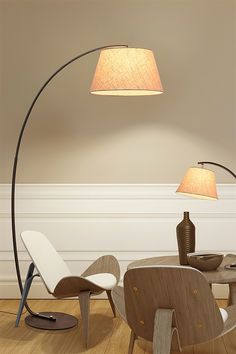 a lamp that is on top of a table next to a chair with a vase