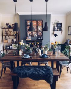 a dining room table with flowers and candles on it