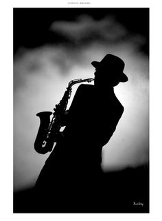 a black and white photo of a man with a saxophone in his hand, against a dark background