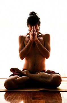 a naked woman sitting on top of a wooden floor in front of a white wall