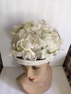 "Vintage 1960's hat. White floral with Green leaves bucket style hat. The label is *SEARS Fashion Millinery*. Sears Roebuck and Co. USA. *MORE INFORMATION BELOW* CONDITION: No issues noted. MEASURES: Inside circumference~21 1/2\" Height~5\" Front to back~8\" Left to right~7\" *WE APOLOGIZE~BUT WE NO LONGER SHIP TO GERMANY, ITALY OR SPAIN. IF ORDERS COME IN FROM GERMANY, ITALY OR SPAIN, WE WILL HAVE TO CANCEL THEM AND REFUND YOUR MONEY. SORRY FOR THIS INCONVENIENCE*" White Retro Bucket Hat With Curved Brim, White Vintage Cloche Fascinator, Vintage White Cloche Fascinator, White Bucket Hat For Kentucky Derby, Vintage White Headpiece For Kentucky Derby, Retro Wide Brim White Hat, Retro White Wide Brim Hat, White Wide Brim Retro Hat, Vintage White Brimmed Hat