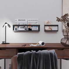 a desk with a chair, lamp and pictures on the wall