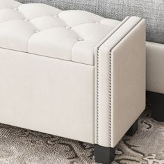 an upholstered white bench sitting on top of a rug