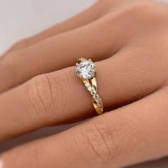 a woman's hand with a diamond ring on top of her finger and an engagement band