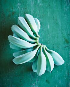 a bunch of white bananas on a green surface