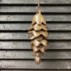 a metal pine cone hanging from a chain