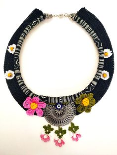 a necklace with flowers and an owl on it