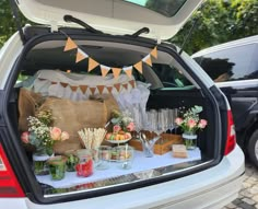 the back of a car with food and drinks in it's trunk, as well as decorations