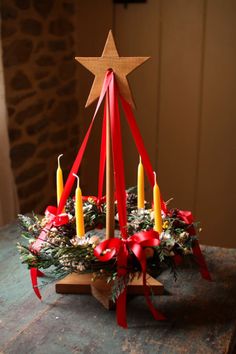 a christmas tree with candles in it on top of a table