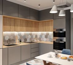 a modern kitchen with grey cabinets and white counter tops, along with blue chairs in front of the table