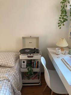 a bedroom with a bed, desk and record player on it's shelf next to the bed