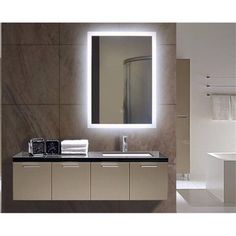 a bathroom with a sink, mirror and lights on the wall above it's counter