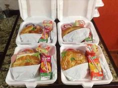 four plastic containers filled with food on top of a counter