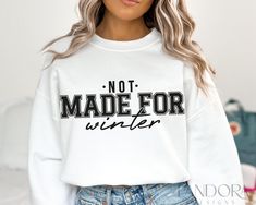 a woman wearing a white sweatshirt with the words'not made for winter'printed on it