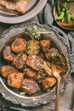 a bowl filled with fried meat and garnished with herbs