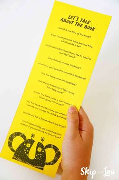 someone holding up a yellow bookmark with the words let's talk about the book