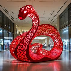 a large red sculpture sitting inside of a building