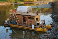 a small houseboat floating on top of a lake