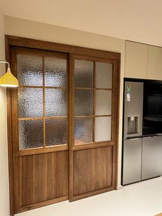 a kitchen with an oven and refrigerator next to a window that has frosted glass on it