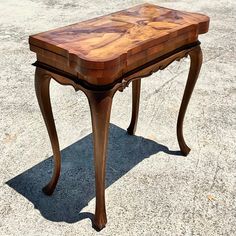 a wooden table sitting on top of a cement ground