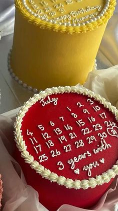 two cakes with white frosting and red icing