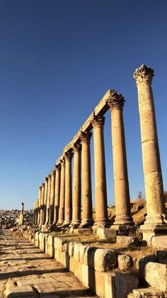 an old row of stone pillars on the side of a road