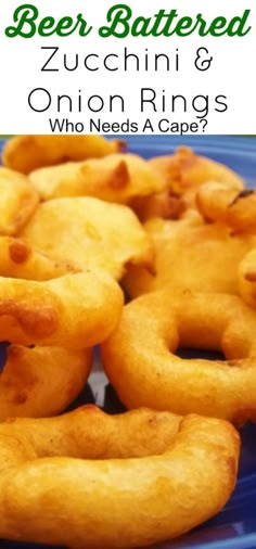 fried onion rings on a blue plate with text overlay reading beer battered zucchini & onion rings who needs a cape?