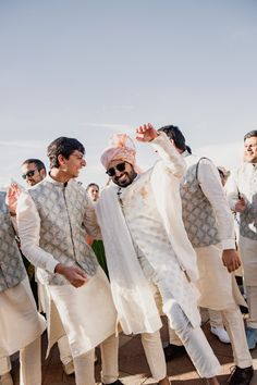 the grooms are dressed in all white