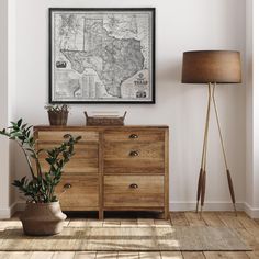 a living room with a large map hanging on the wall next to a wooden dresser