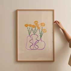 a woman is looking at a painting on the wall with yellow flowers in a vase