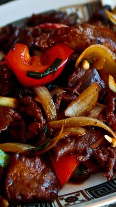 a plate with meat, onions and peppers on it