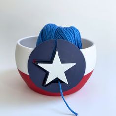 a white and red bowl with a blue string in the shape of a star on it