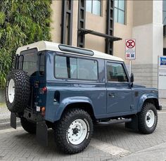 a blue jeep parked in front of a building