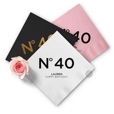 three napkins with the number forty and one pink rose on them, sitting next to each other